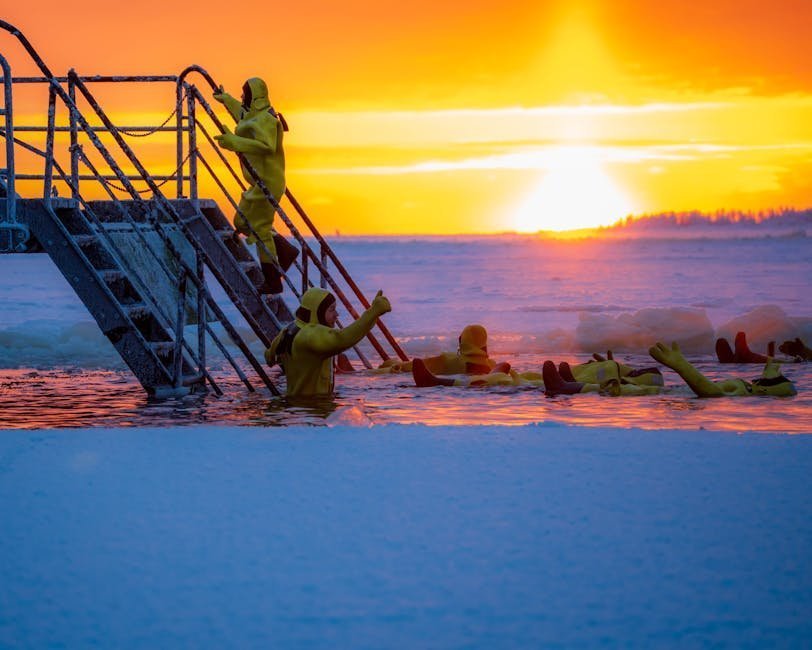 Outdoor cold water swim group emerging from a lake in winter wearing tow floats