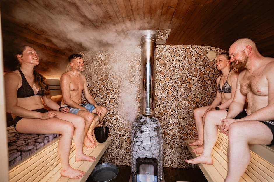 Outdoor wood-fired sauna by a frozen lake with snow surrounding the cabin