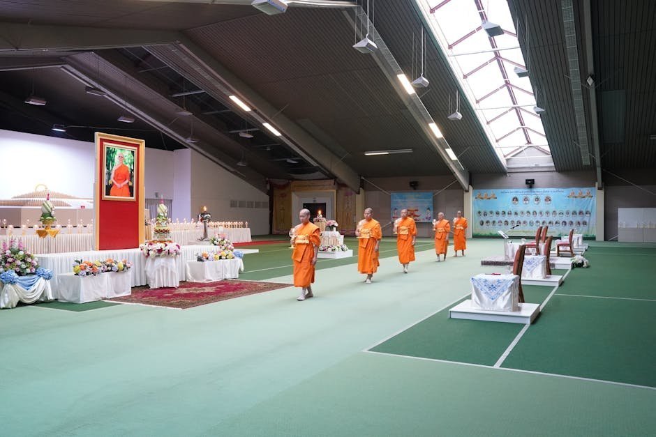 Buddhist meditation hall with rows of cushions facing an altar with candles and flowers