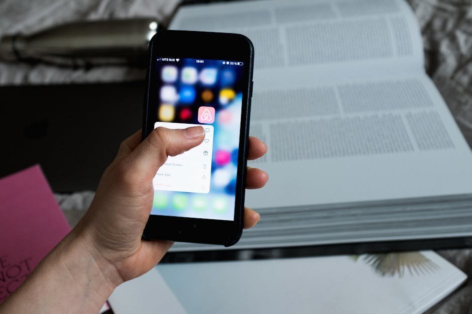 Smartphone displaying journaling app next to a paper notebook on a window sill