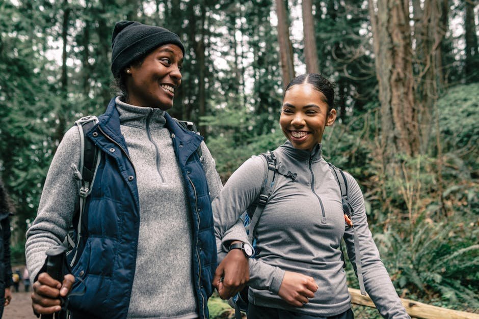 Two women on a hiking trail laughing together, representing reciprocal supportive friendship