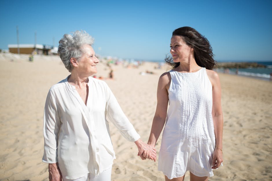 Adult daughter holding hand of elderly mother in armchair during geriatric psychiatry consultation