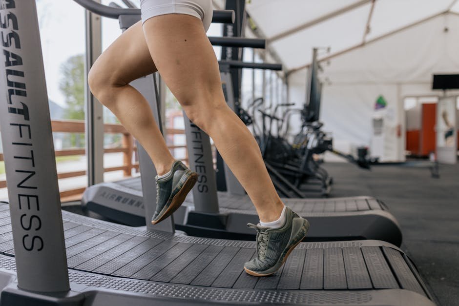 Person running on a treadmill at a brisk pace with heart rate monitor visible